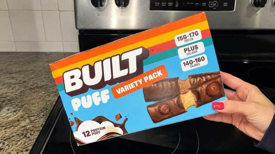 womans hand holding a box of protein bars