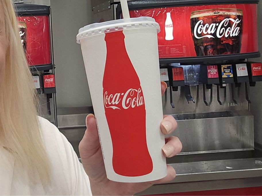 hand holding coca cola cup in store