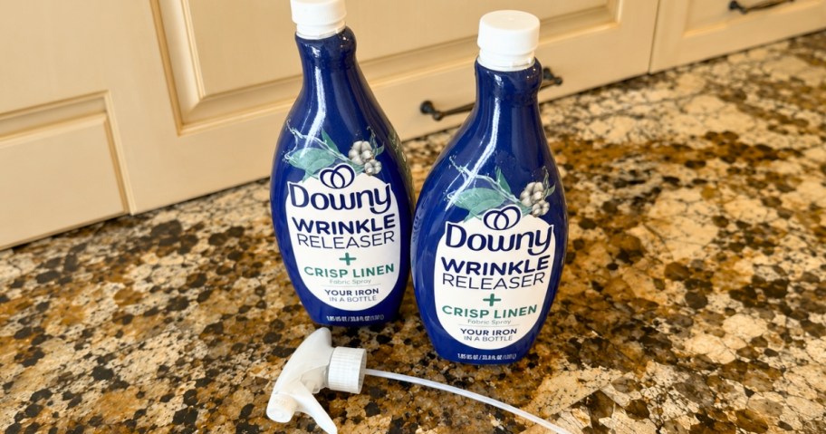 two bottles of Downy Wrinkle Releaser spray with a spray nozzle on a counter