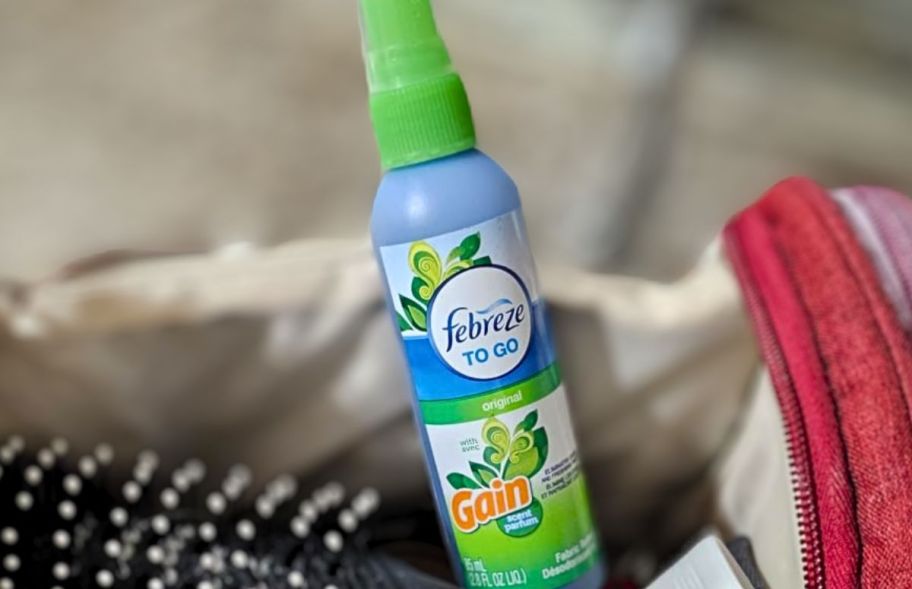 a bottle of febreze fabric refresher sticking out of a duffle bag