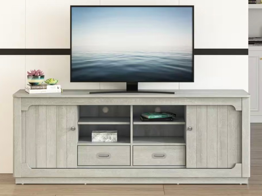 gray tv stand with tv on top 