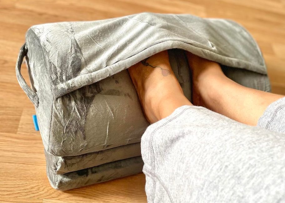 feet inside gray foot rest with cover