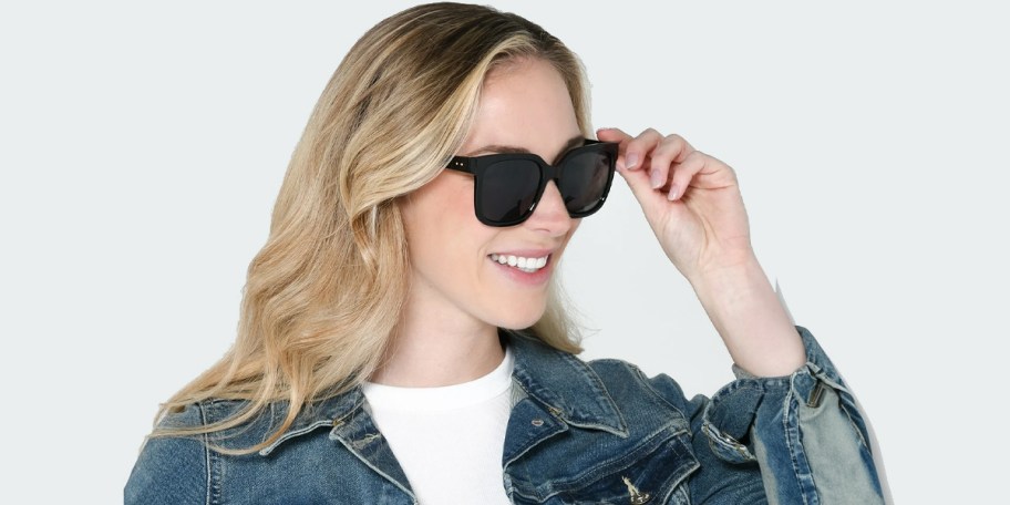 blonde woman wearing jean jacket and black sunglasses 