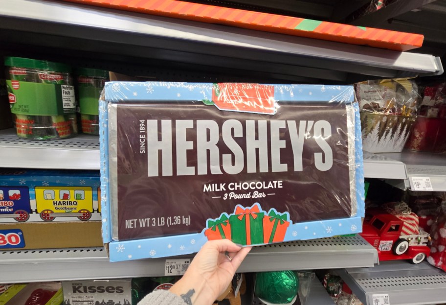 A hand holding a giant Hershey's chocolate bar.