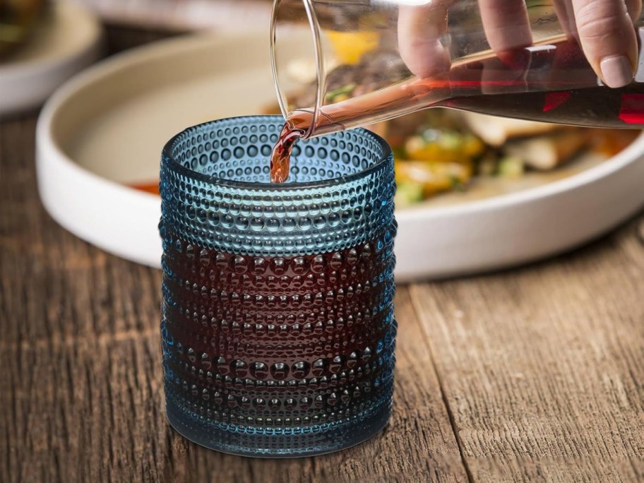 pouring drink in to navy blue glass