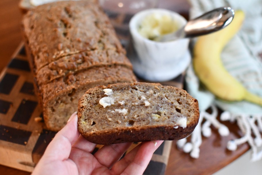 holding banana bread with butter