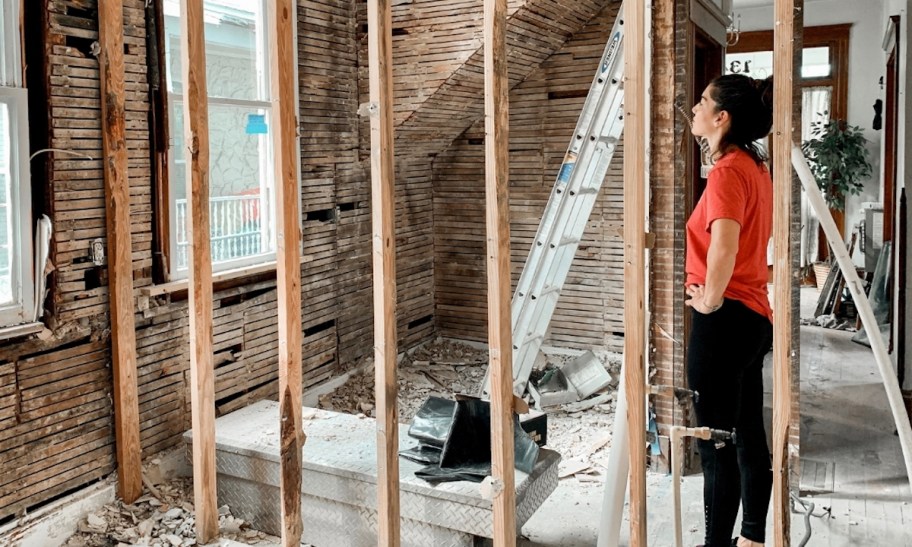 woman standing near studs in construction room