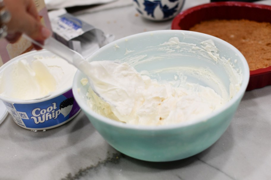 mixing cool whip with cream cheese