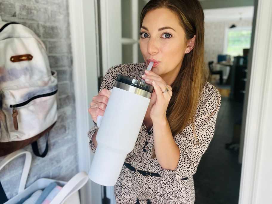 woman sipping from white ozark trail tumbler