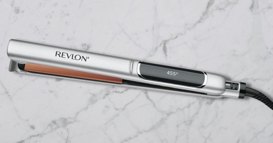 a silver and black Revlon flat iron hair tool on a marble counter