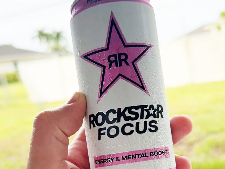 person holding a rockstar drink