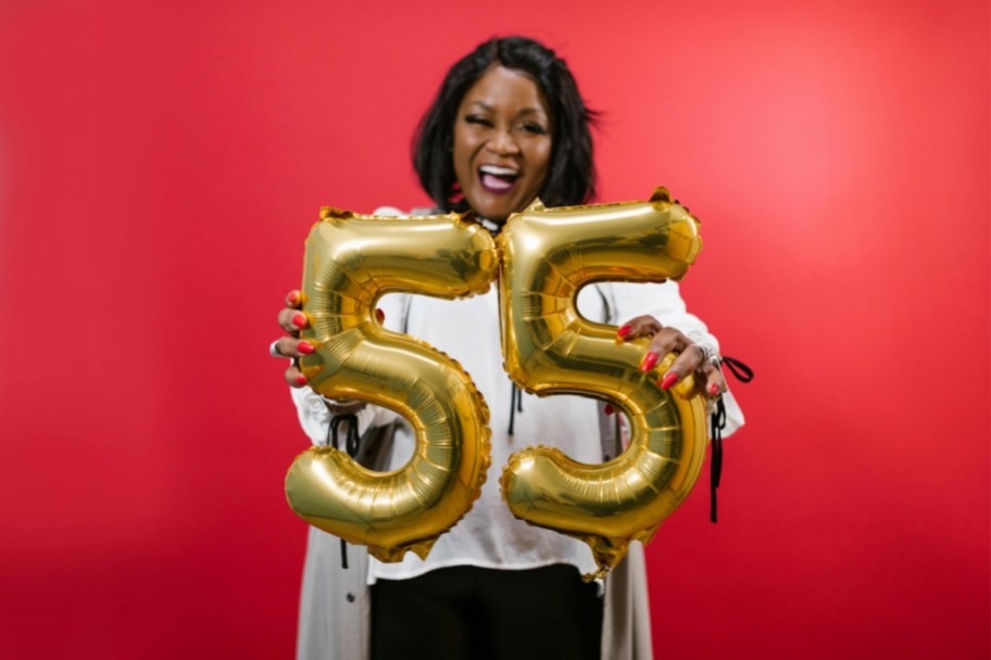 woman holding 55 balloons