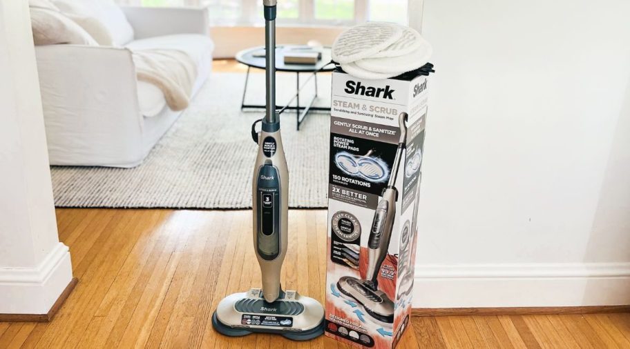 a shark steam mop next to its packaging in a home hall way