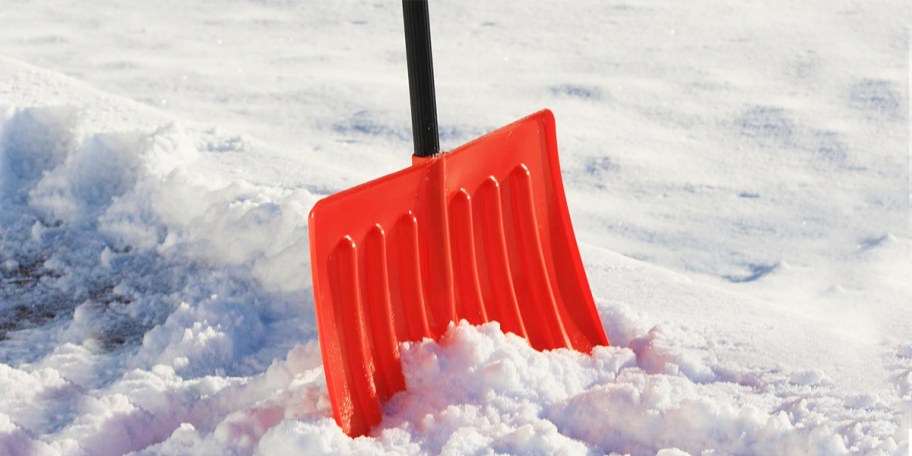 orange snow shovel in snow 