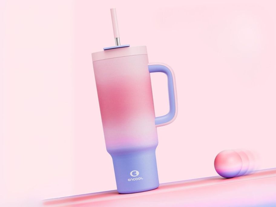 40oz tumbler sitting on a slant with a ball rolling next to it