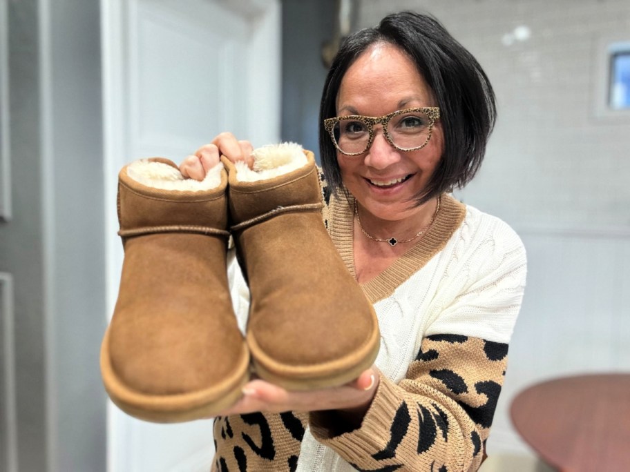 woman holding a pair of dearfoam ugg lookalikes after cleaning