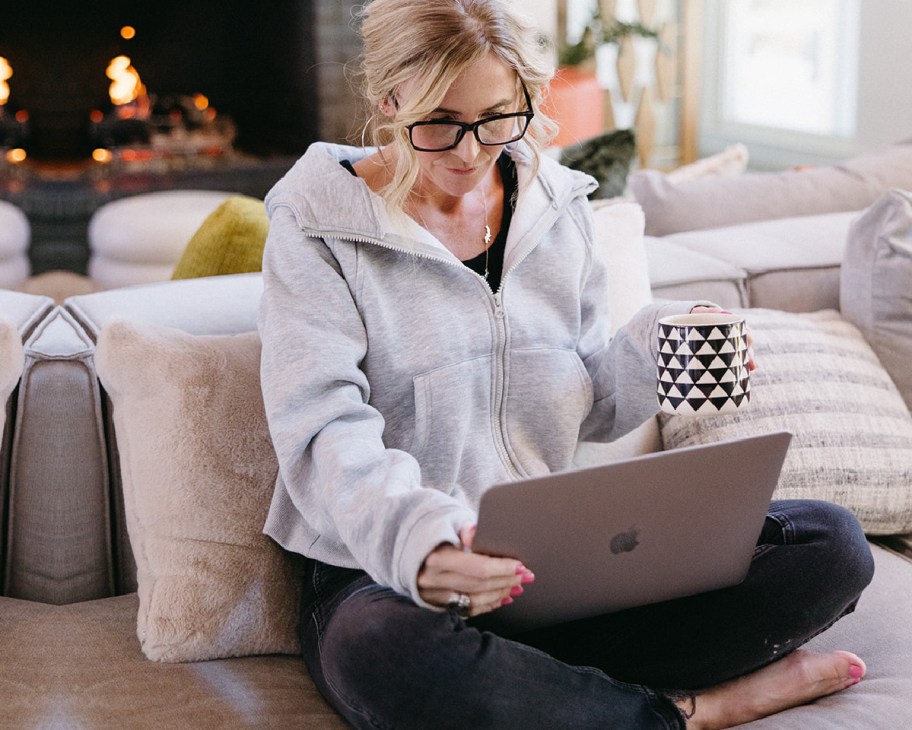 woman on laptop holding coffee mug