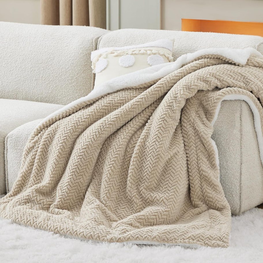Beige Blanket placed on an off white couch.