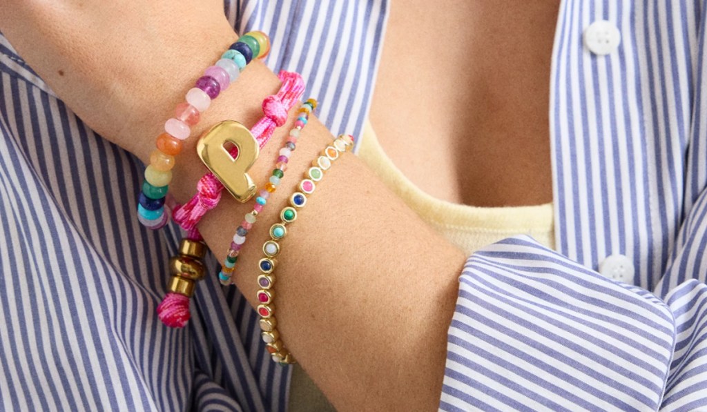 Woman wearing colorful bracelets with bubble letters, and beads