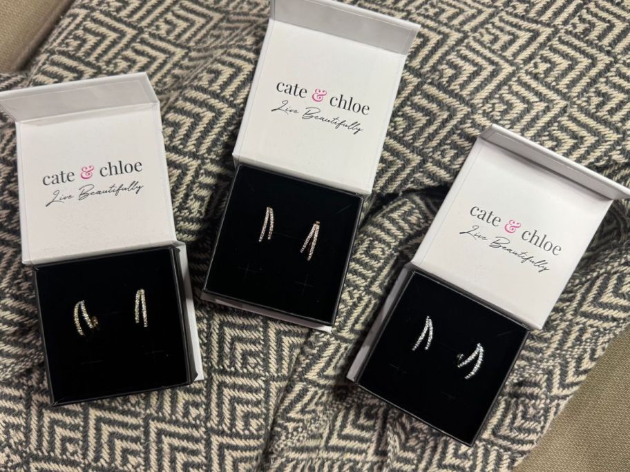three different sets of Cate & Chloe Corina 18K Gold-Plated Swarovski Crystal Hoop Earrings in their gift boxes