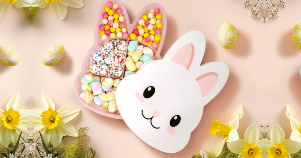 Bunny shaped snack box filled with different candies on pink background