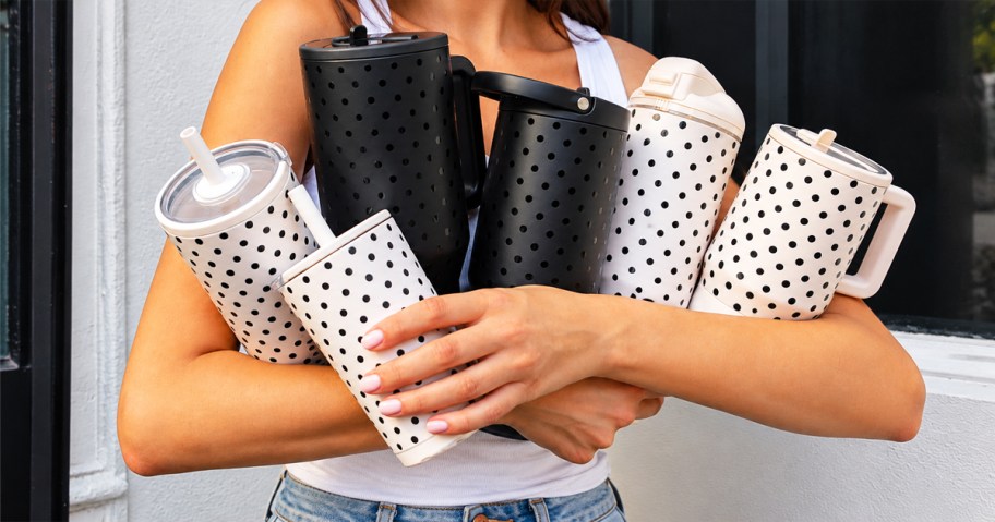 woman's arms full of polka dot print tumblers and bottles