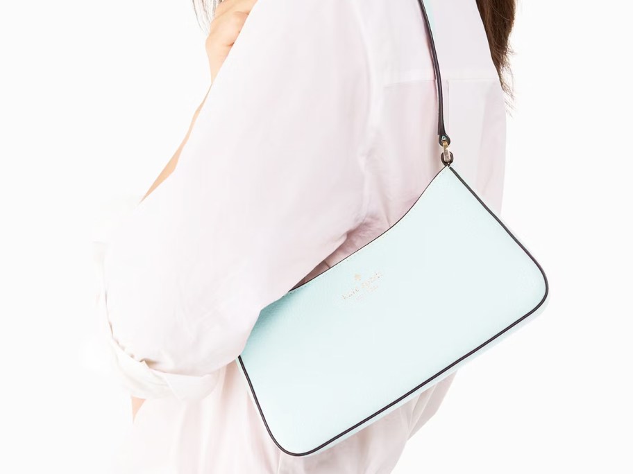 woman in a white top with a light blue shoulder bag