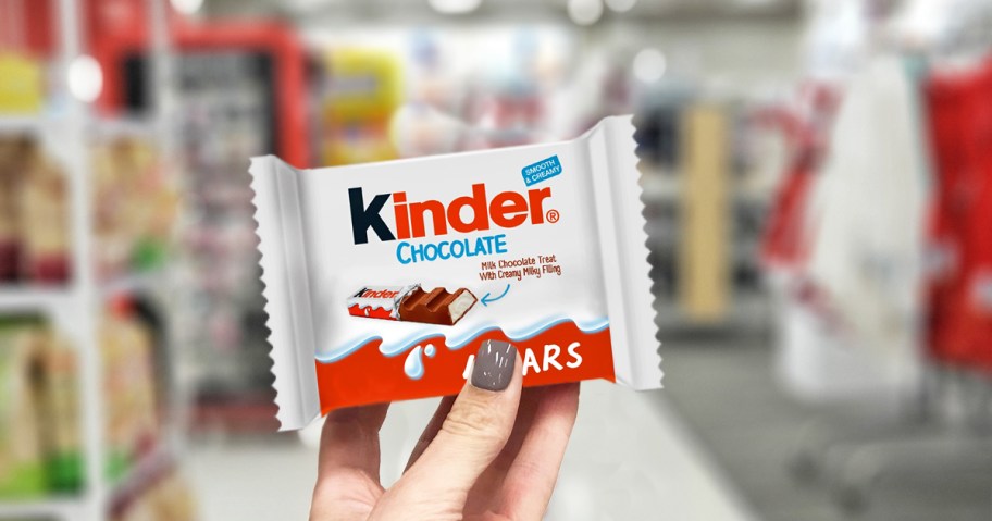 hand holding up a kinder bar in store