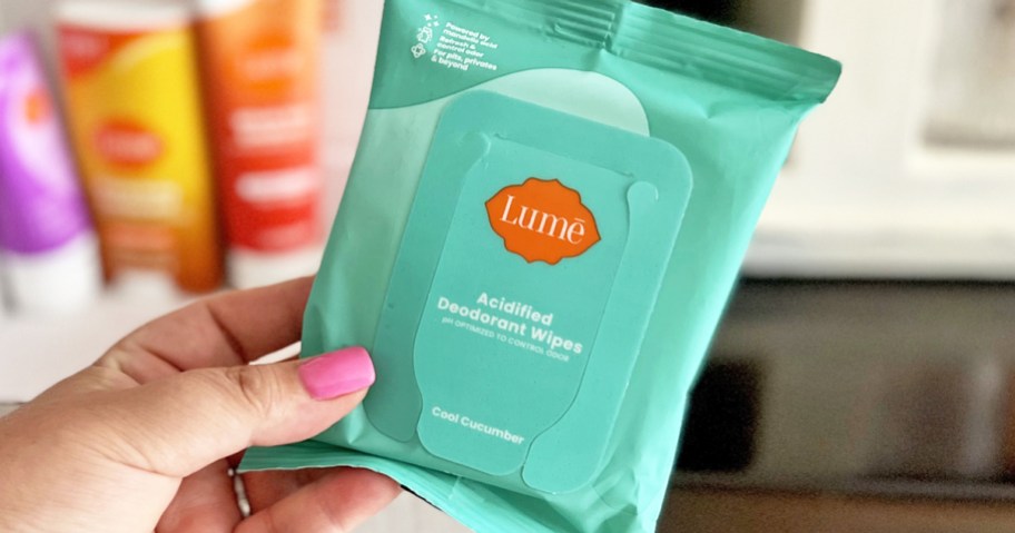 hand holding up a green pack of Lume Acidified Deodorant Wipes