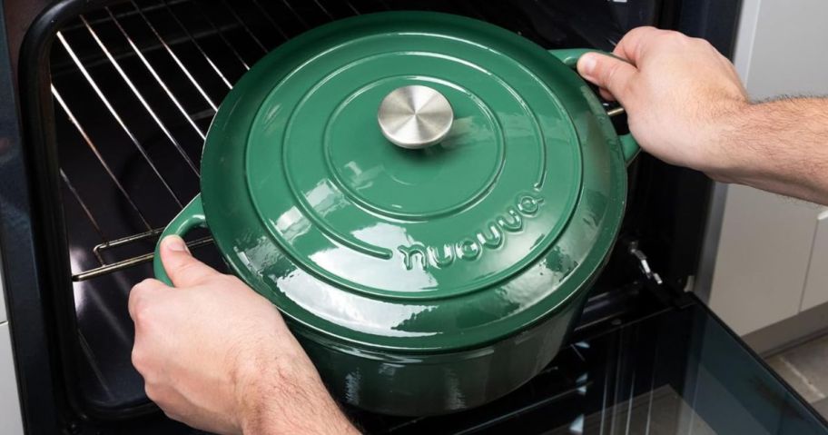 A Dark Green Nuovvo Dutch oven being placed in an oven