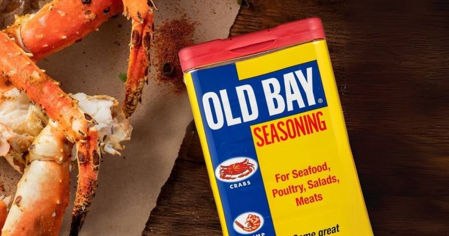 container of old bay seasoning on table with crab legs