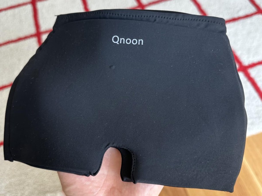 hand holding a black Migraine Relief Cap