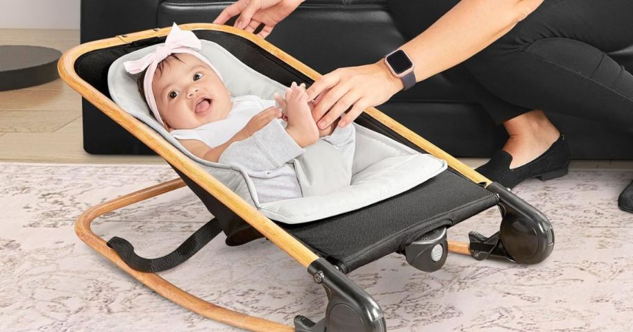 A baby in a small rocker seat