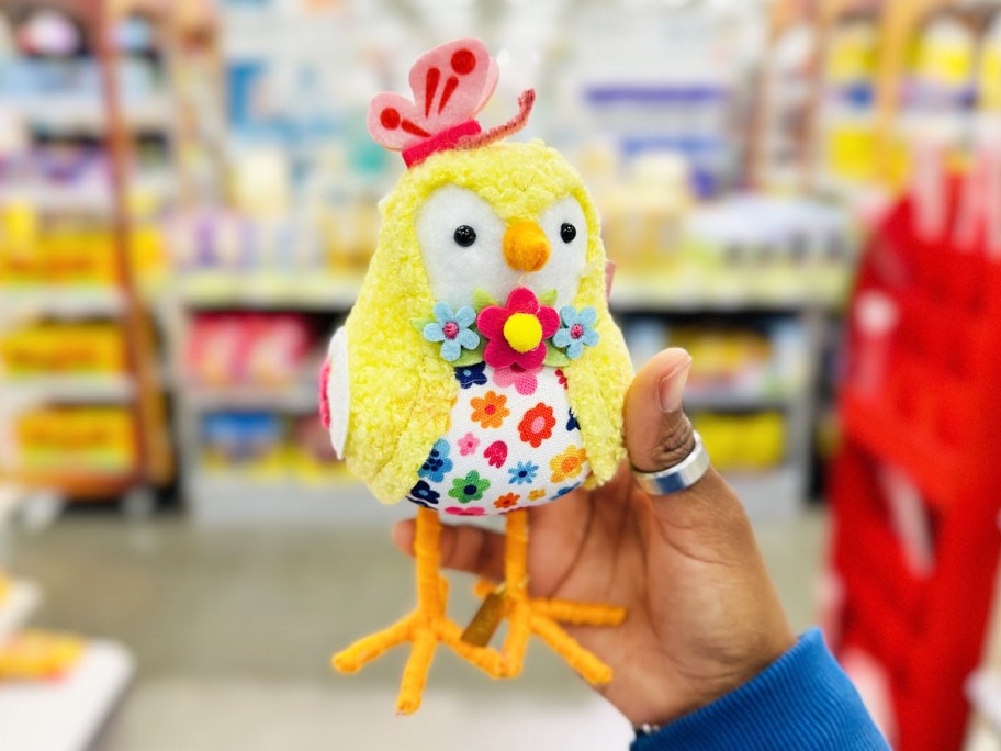 hand holding a felt bird dressed as a yellow chick