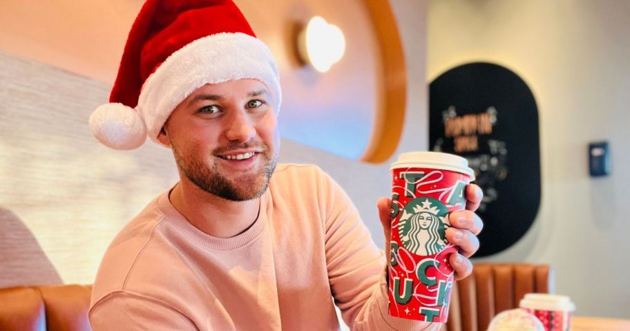 Man wearing a Santa hat while holding a Starbucks cup