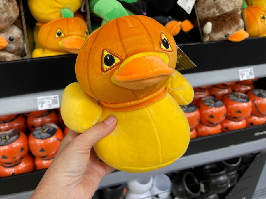 A person holding an orange duck 