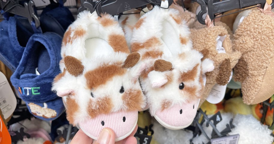 hand touching a pair of farm animal baby slippers