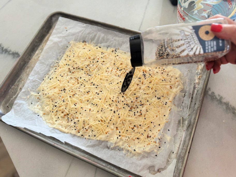 adding everything bagel seasoning to crackers