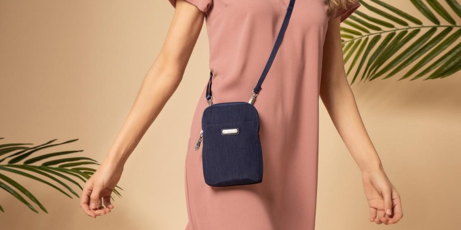 woman in pink dress wearing navy blue crossbody bag 