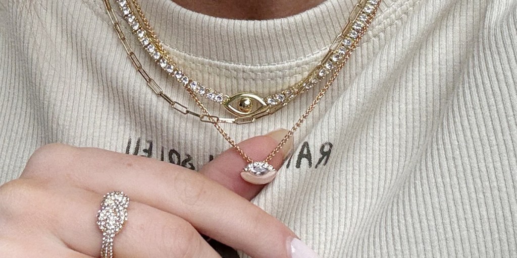 hand reaching for gold necklaces