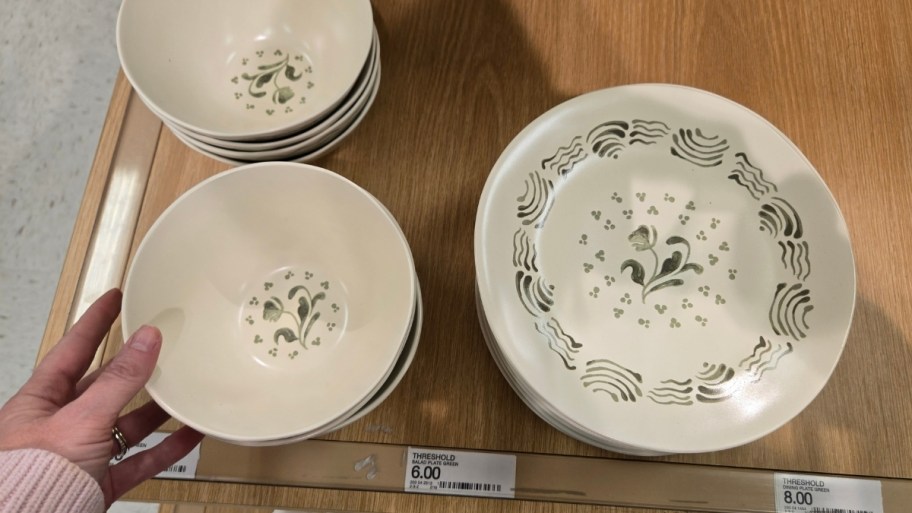 womans hand holding a hand painted bowl