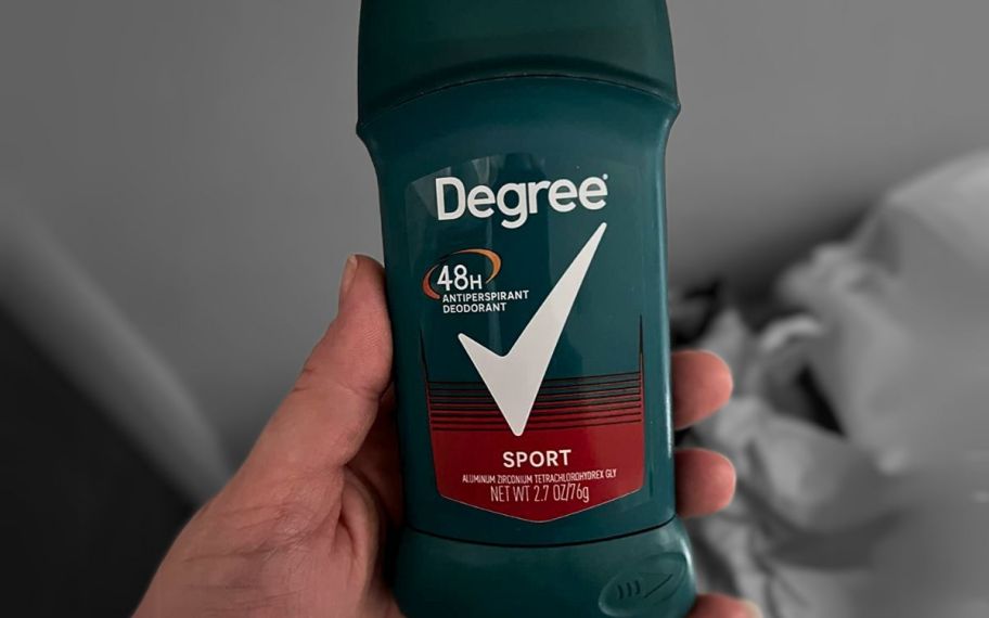 a mans hand holding a degree deodorant stick