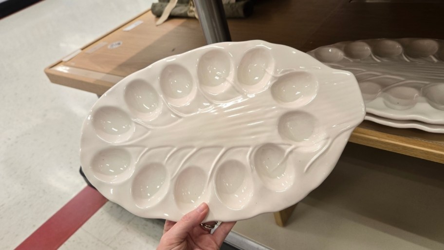 zwomans hand holding an egg serving platter