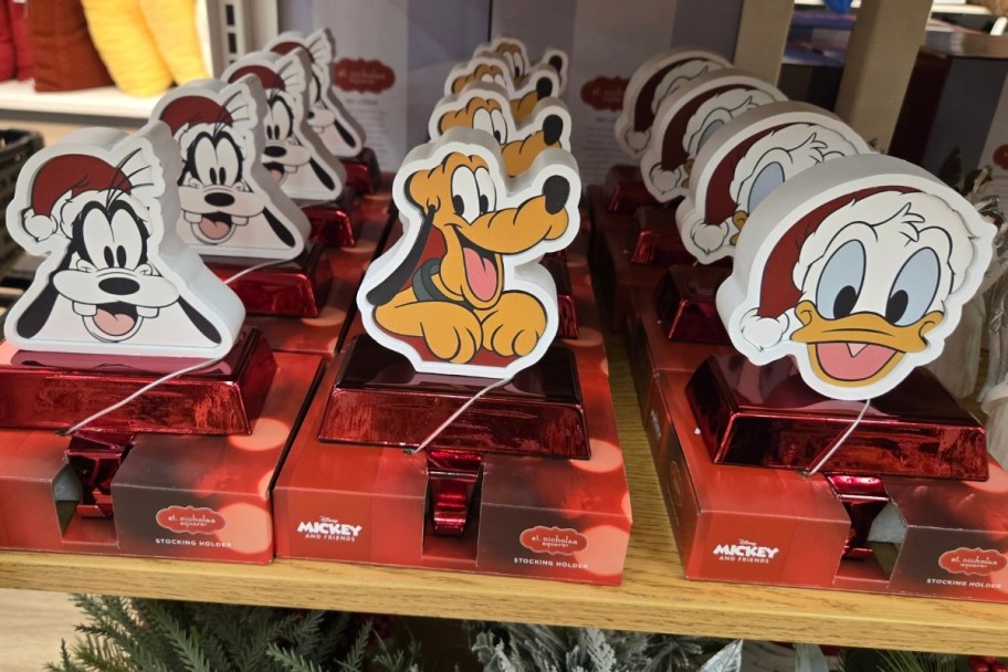 goofy pluto and donald duck stocking holders on a store shelf