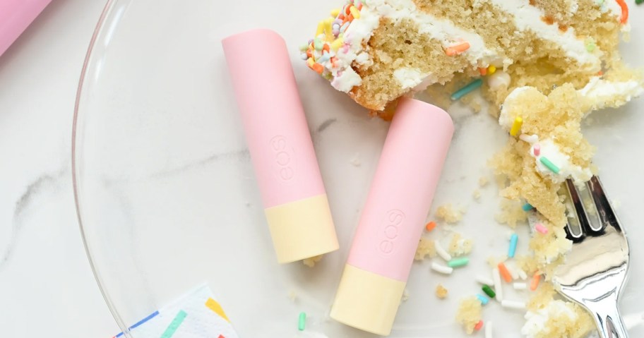 two tubes of eos lip balm near slice of cake