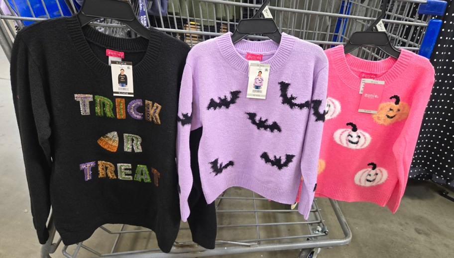 halloween sweaters hanging on shopping cart 