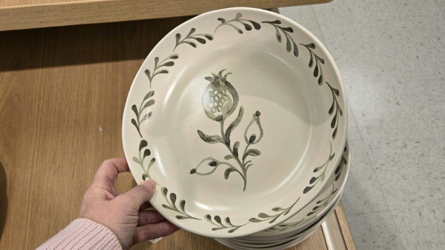 womans hand holding a hand painted bowl