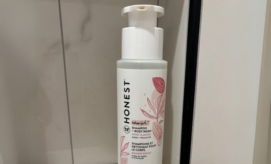 a bottle of honest company shampoo and body wash in a shower alcove