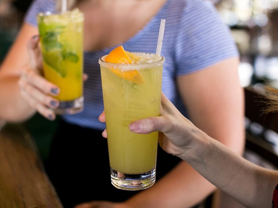 two people holding margaritas