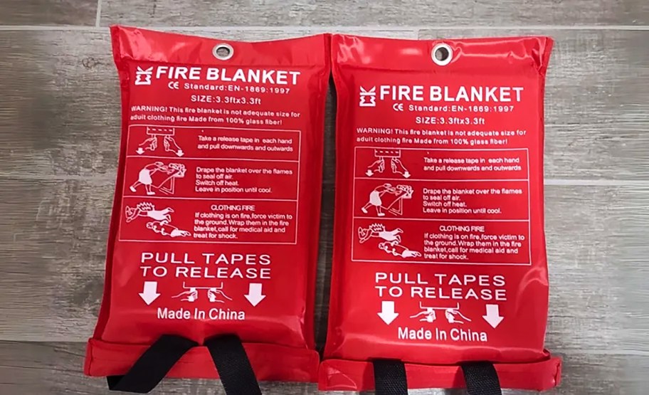 two red fire blankets in the packaging on the floor